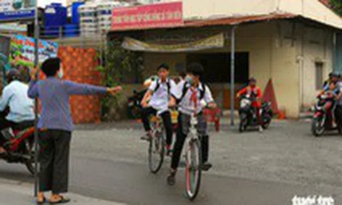 'Bà ngoại Hai' cầm bảng canh xe cho học trò qua đường an toàn